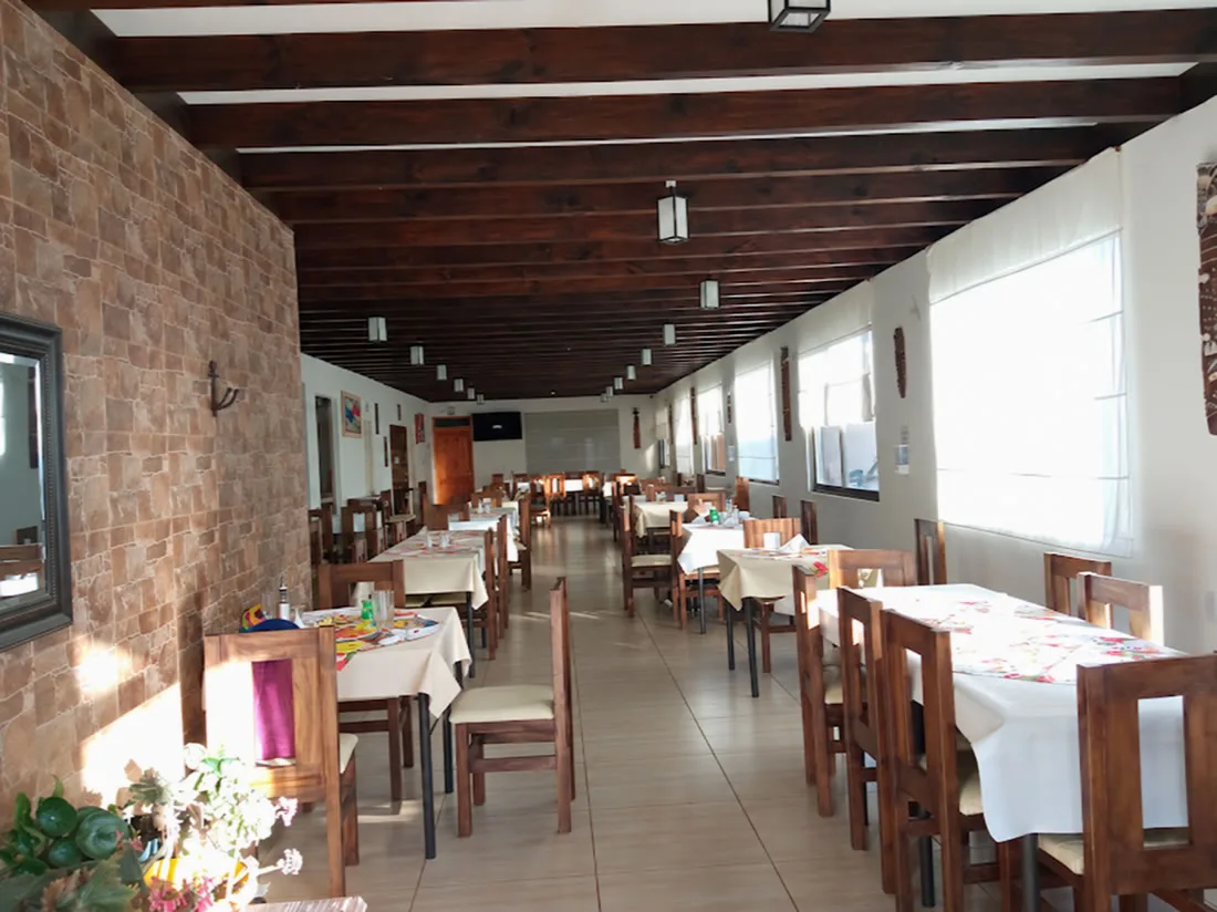 Salón de Barlovento Restaurant, con mesas junto a grandes ventanas y vigas de madera