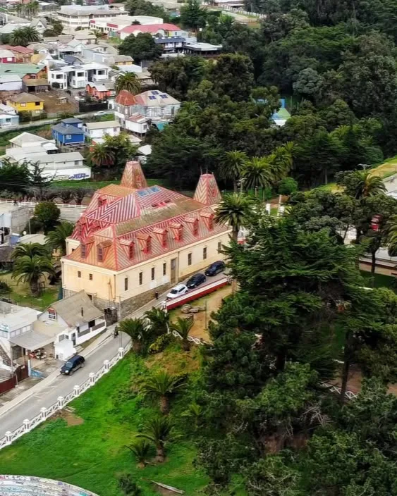 Vista aérea de Pichilemu, con un edificio histórico entre jardines y palmeras