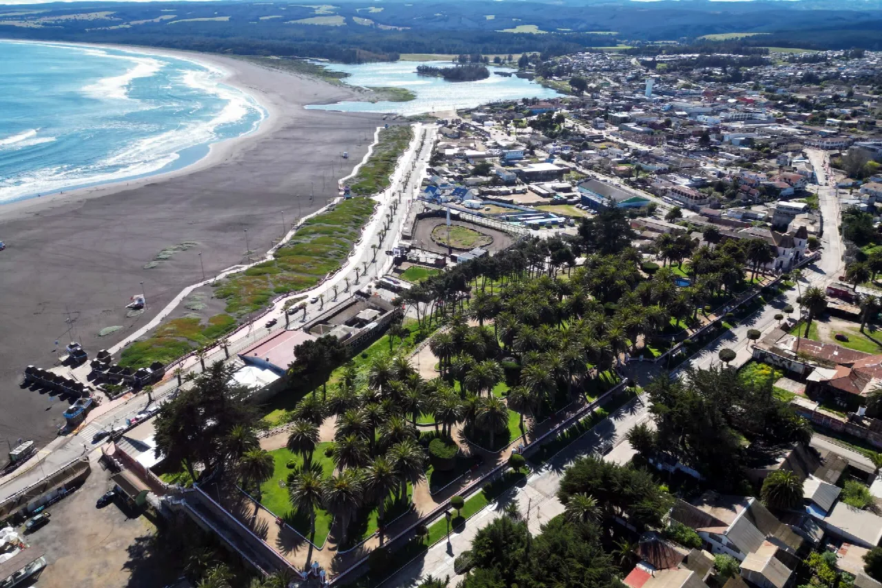 Vista aérea de Pichilemu, con la playa, el paseo costero, jardines con palmeras y la ciudad